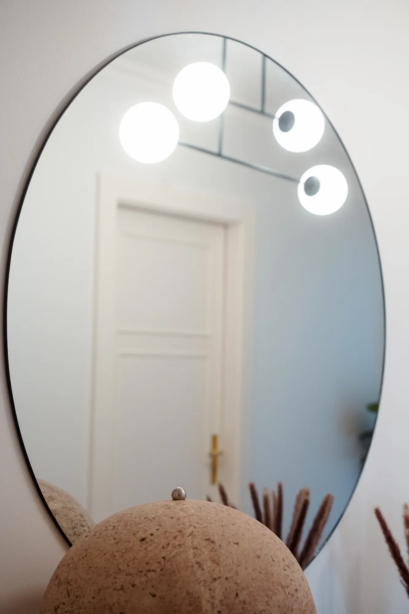 Le miroir rond et les luminaires du couloir