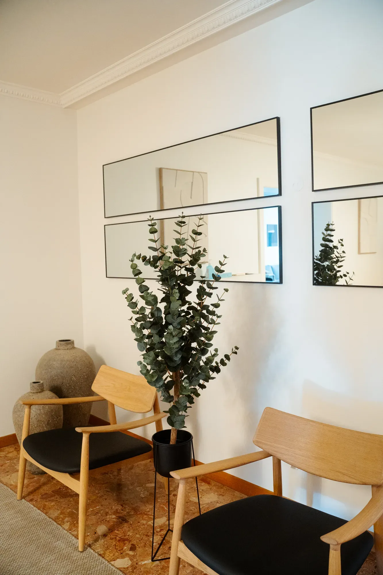 Coin lecture avec eucalyptus et fauteuils en bois clair
